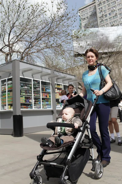 Kvinna med barn i barnvagn — Stockfoto