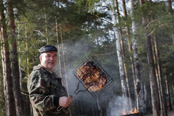 Uomo dimostrando griglia con carne — Foto Stock