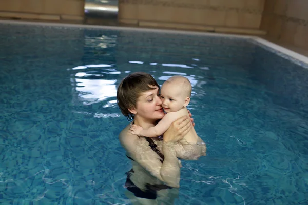 Mãe e criança descansando na piscina — Fotografia de Stock