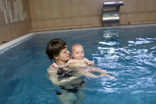 Mãe segurando criança na piscina — Fotografia de Stock