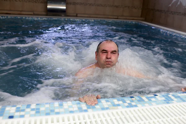 Мужчина расслабляется в бассейне — стоковое фото