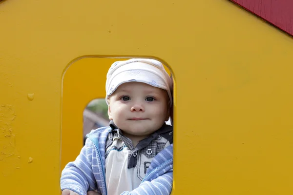 Ребенок позирует в жёлтом доме — стоковое фото
