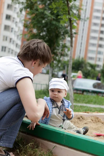 Madre y niño en caja de arena — Foto de Stock