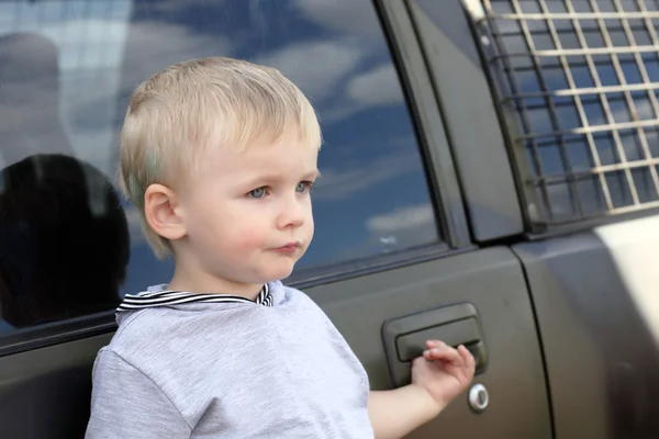 Serious child and car — Stock Photo, Image