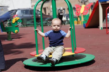 Roundabout üzerinde oturan çocuk