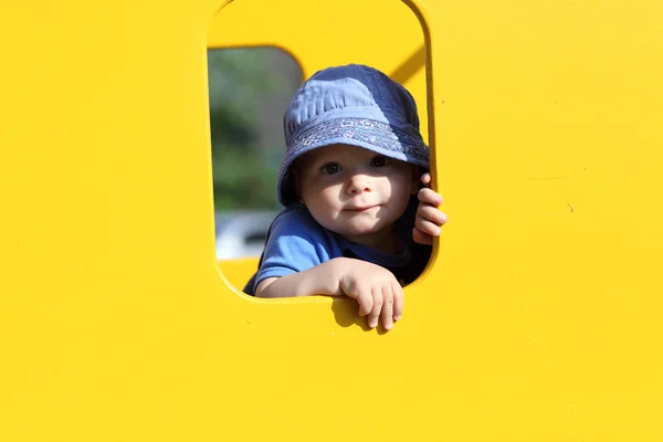 Ребенок в желтом игрушечном домике — стоковое фото