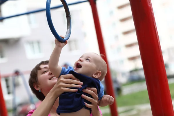 Criança alegre pendurada em anéis — Fotografia de Stock