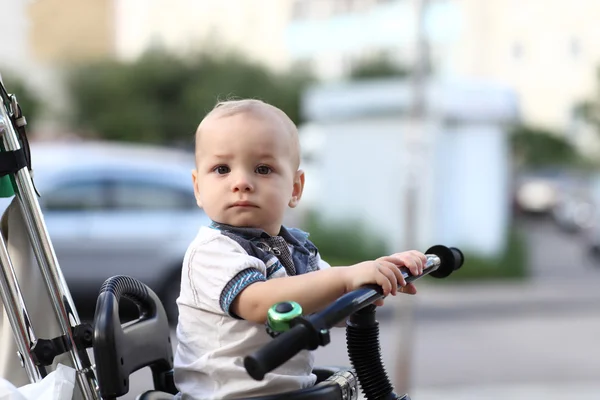 Мыслящий ребенок на трёхколесном велосипеде с рукояткой! — стоковое фото