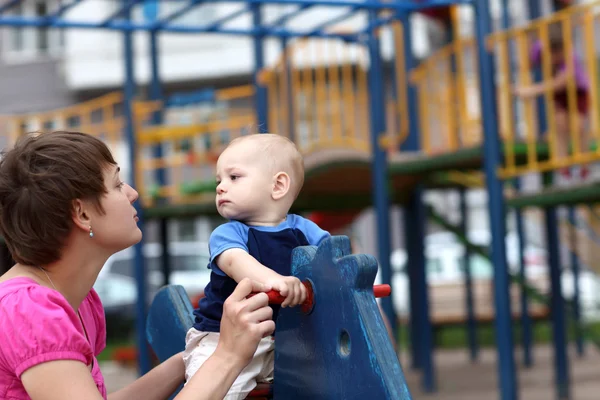 Criança com mãe no parque infantil — Fotografia de Stock