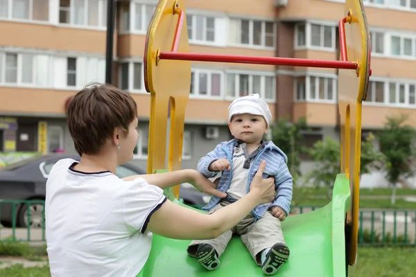 Serious child sitting on slide — Stock Photo, Image