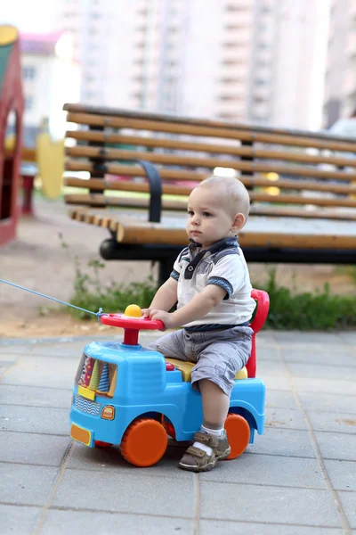 Ребенок сидит на игрушечной машине — стоковое фото