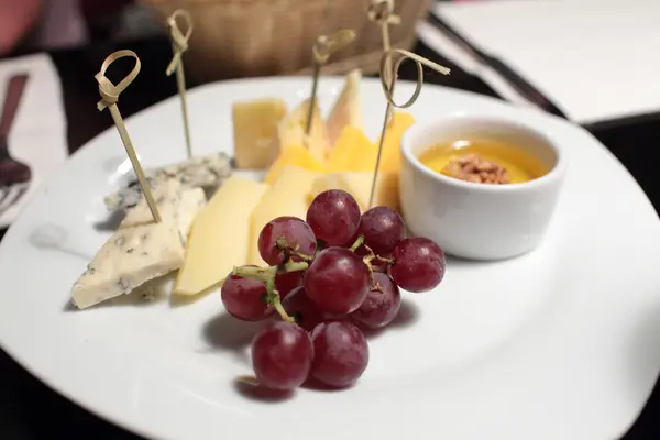 Various cheeses and grapes — Stock Photo, Image
