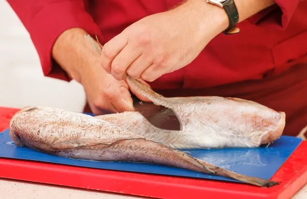 Chef em restaurante cortando peixe cru — Fotografia de Stock