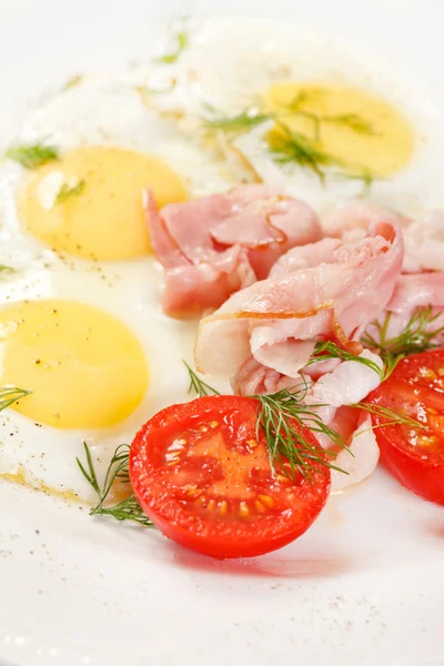 Fried eggs with bacon and vegetables — Stock Photo, Image