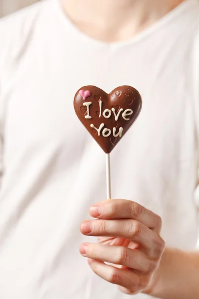 Man med choklad hjärta i händerna — Stockfoto