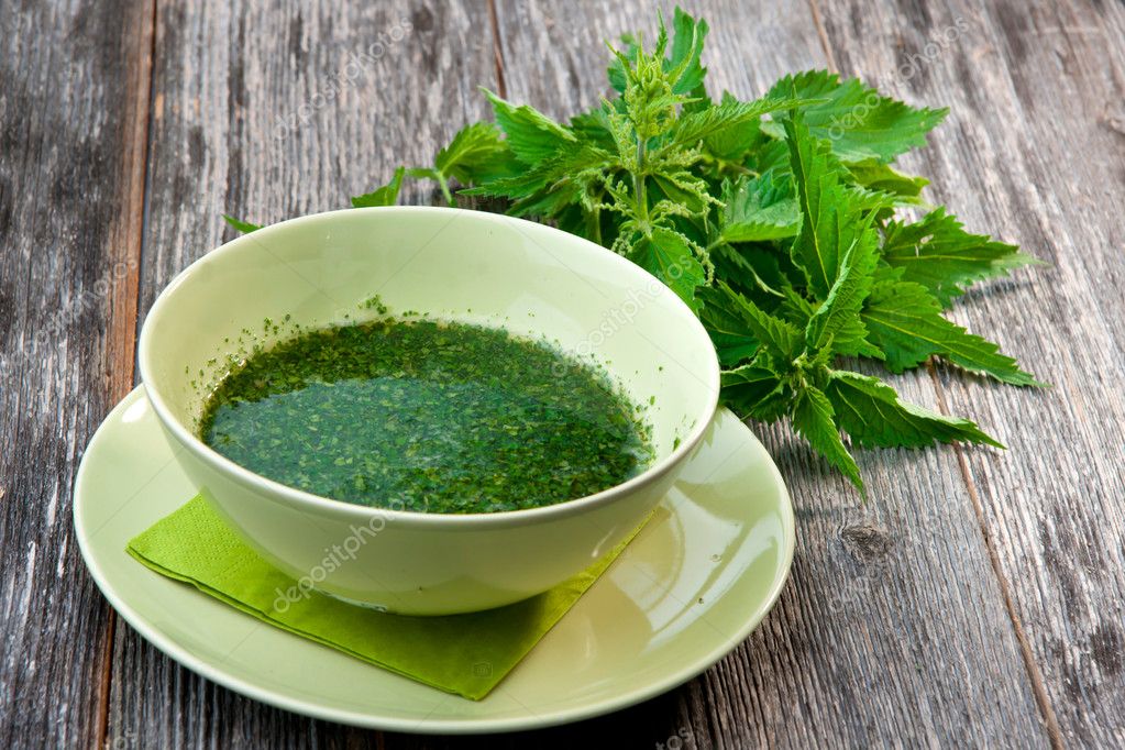 Stringing nettle soup on wooden table