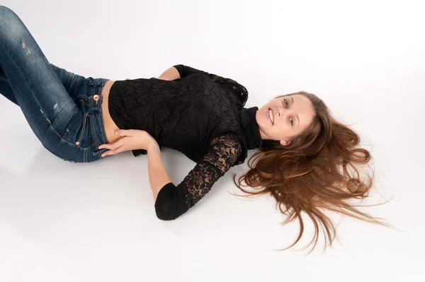 Sorridente giovane donna sdraiata sul pavimento — Foto Stock