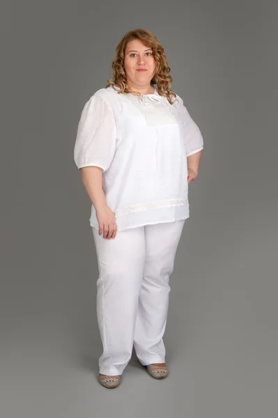 Smiling fat woman on gray background — Stock Photo, Image