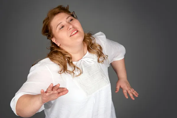 Dansande fet kvinna på grå bakgrund — Stockfoto