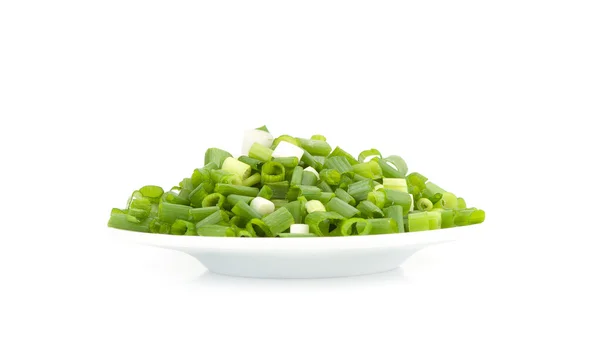 Нарезанный зеленый лук на тарелке — стоковое фото