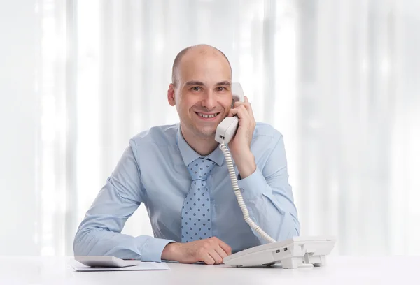 Hombre de negocios en el escritorio en la oficina hablando por teléfono —  Fotos de Stock