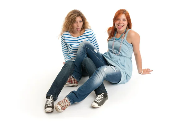 Zwei lustige junge Mädchen zeigen ihre Zunge — Stockfoto