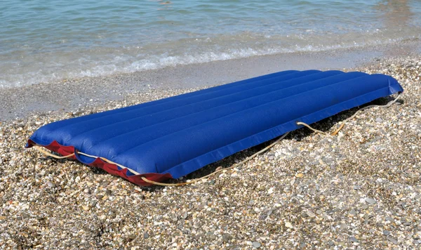 Balsa inflable azul en la playa de arena Imagen de archivo