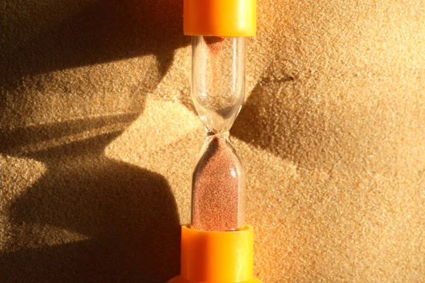 Песочные часы на песке — стоковое фото