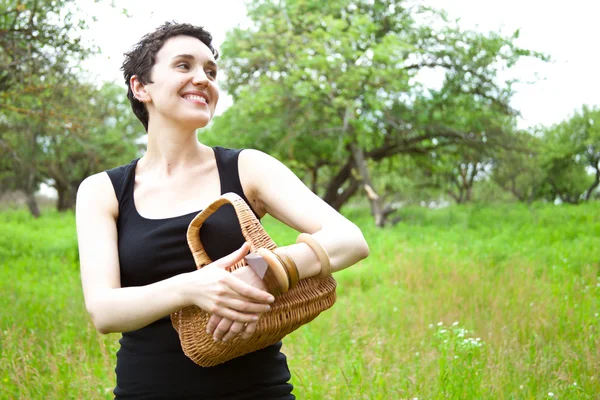 Woman with basket in the garden — Stock Photo, Image