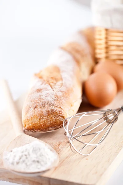 Pão, farinha, ovos e utensílio de cozinha — Fotografia de Stock