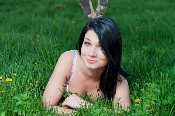 Uśmiechnięta kobieta, leżąc na trawie. — Zdjęcie stockowe