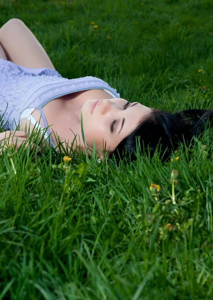 Woman lies on her back in grass. — Stock Photo, Image