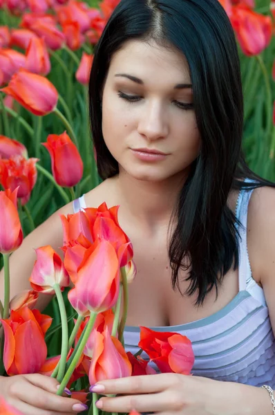 Mujer mira tulipanes . — Foto de Stock