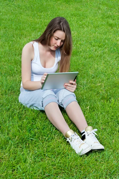 Meisje werkt aandachtig op Tablet PC. — Stockfoto