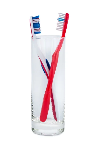 Two toothbrushes in a glass beaker. — Stock Photo, Image