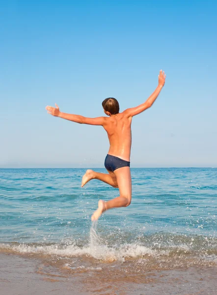 Boy jumping on beach. — Stock Photo, Image