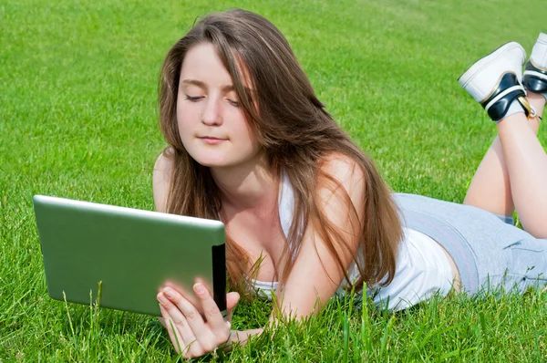 Student liggend op gras met Tablet PC. — Stockfoto