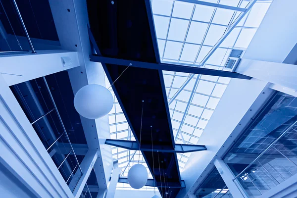 stock image Modern business interior with glass ceiling in blue tones