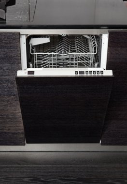 Open dish washer machine on black hardwood kitchen clipart