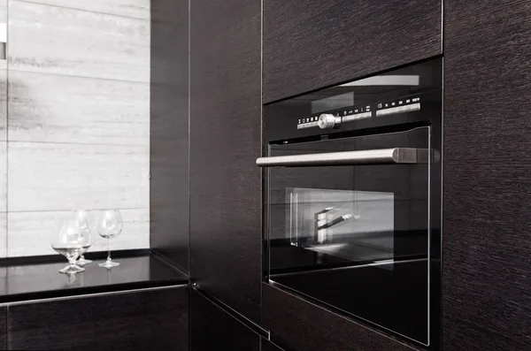 Parte da cozinha em madeira preta com microondas — Fotografia de Stock