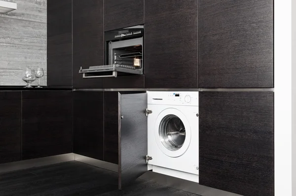 Build-in washing machine and cooker on modern black kitchen — Stock Photo, Image