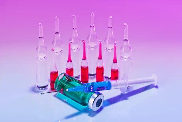 Red Ampoules and syringe still life in vivid colors