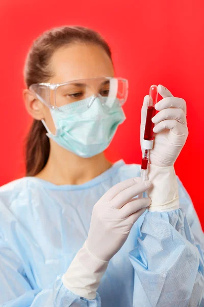 Mujer joven médico haciendo análisis de sangre con tubo de ensayo y siri — Foto de Stock