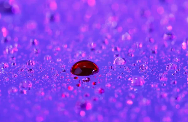 Gota de sangre sobre fondo de agua translúcido abstracto, vista macro —  Fotos de Stock