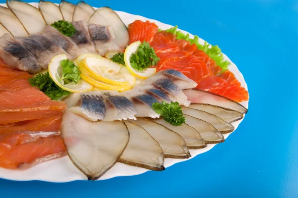Röd och vit fisk på en tallrik med citron — Stockfoto