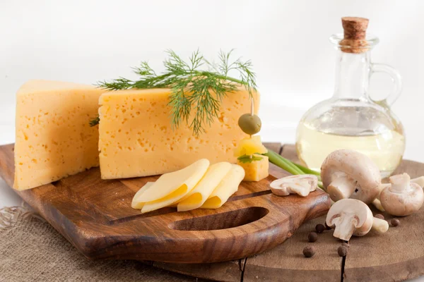 Сыр с зеленью и грибами на деревянной доске — стоковое фото