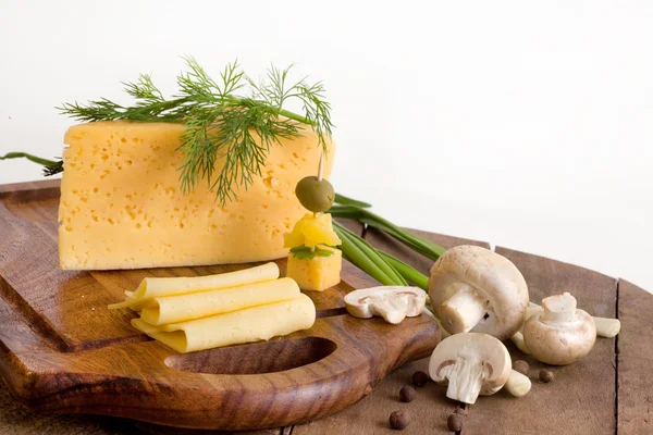 Sýr, zelenina a houby na dřevěné desce — Stock fotografie