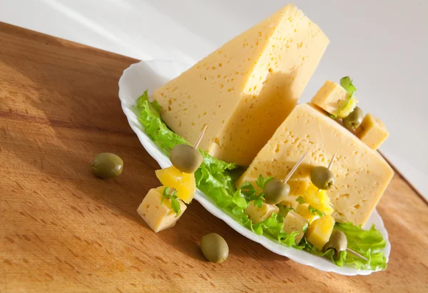Сыр с зеленью и оливками на деревянной доске — стоковое фото