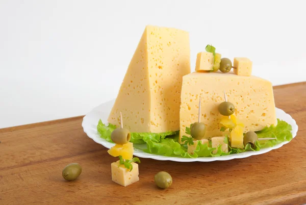 Сыр с зеленью и оливками на деревянной доске — стоковое фото