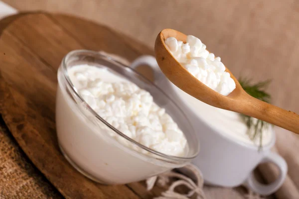 Cottage cheese in a plate and a spoon with cottage cheese — Stock Photo, Image